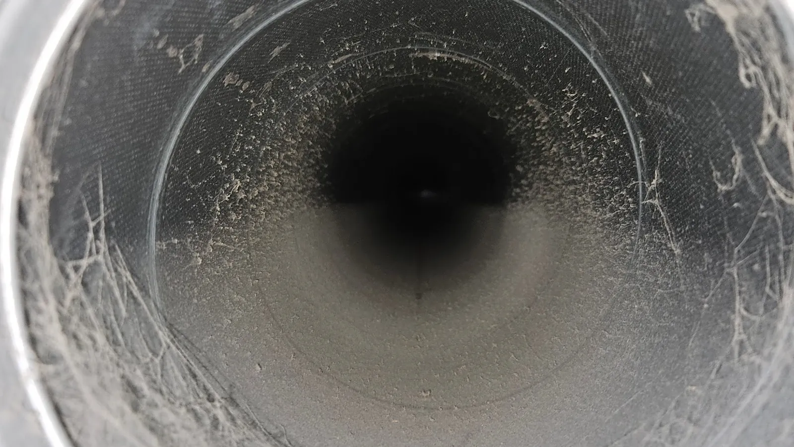 Before cleaning: a duct full of dust and cobwebs